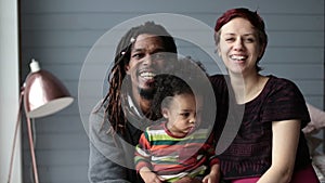 Portrait of happy diverse family with son at home
