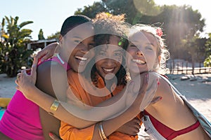 Portrait of happy diverse female friends embracing and smiling at beach, with copy space