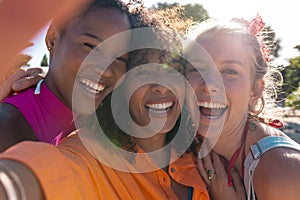 Portrait of happy diverse female friends embracing and smiling at beach, with copy space