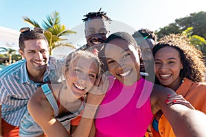 Portrait of happy diverse friends embracing and smiling at beach, with copy space