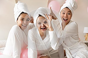 Portrait happy diverse girls wearing bathrobes having fun