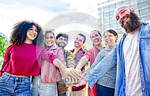 Portrait of happy diverse large group of multicultural friends holding hands making high five stacking them together outdoor.