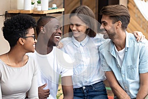 Portrait of happy diverse millennial friends hug at meeting