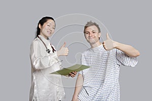 Portrait of happy doctor and patient gesturing thumbs up
