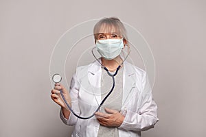 Portrait of happy doctor in white uniform standing with stethoscope on white background