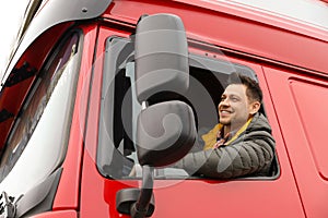 Portrait of happy driver in cab of truck