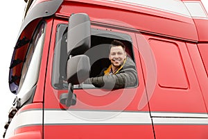 Portrait of happy driver in cab of truck