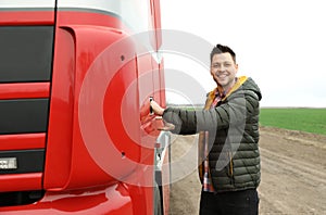 Portrait of happy driver opening door of modern truck