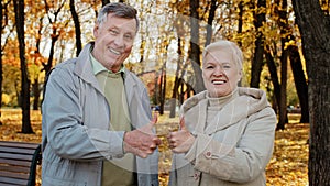 Portrait of happy elderly caucasian family wife husband senior grandparents stand outdoor in autumn park smiling old