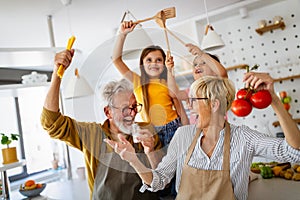 Portrait of happy elderly couple and grandchildren playing together