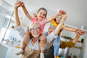 Portrait of happy elderly couple and grandchildren playing together