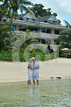 Portrait of happy elderly couple hugging on tropical beach