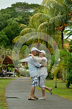 Portrait of happy elderly couple hugging during vacation at tropical resort