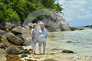 Portrait of happy elderly couple resting on tropical beach