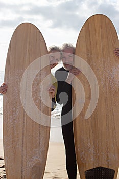 Portrait of happy elderly couple before starting surfing