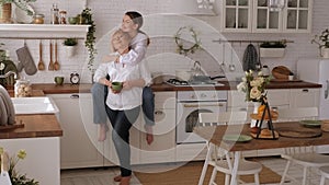 Portrait of a happy elderly mother and daughter in the kitchen, they drink tea.