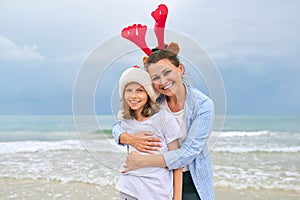 Portrait of happy embracing mom and daughter, celebrating Christmas and New Years
