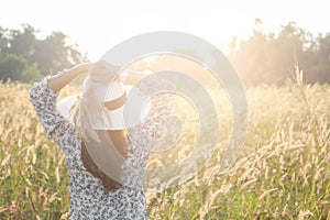 Portrait of happy and enjoying young woman on a meadow on a sunny summer day. Cheerful girl on sunset. Lifestyle and happiness co