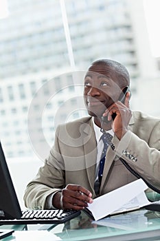 Portrait of a happy entrepreneur making a phone call while reading a document