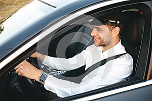 Portrait of happy european man taxi driver wearing uniform and c