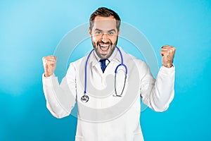Portrait of happy excited doctor in professional medical white coat showing YES