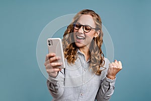 Portrait of a happy excited girl holding mobile phone