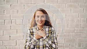 Portrait of happy and excited young woman smiling, laughing and touching face expressing excitement and happiness. Good