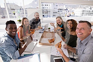 Portrait of happy executives having pizza