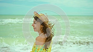 portrait happy expression woman with blowing hair wearing yellow shirt having fun on beach and joyfully running