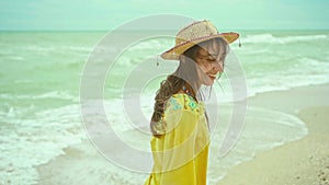 portrait happy expression woman with blowing hair wearing yellow shirt having fun on beach and joyfully running