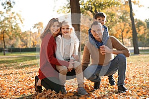 Portrait of happy family in autumn park