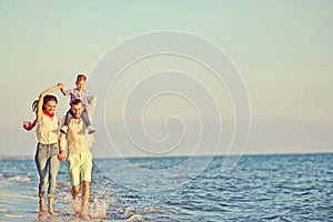 Portrait of happy family and baby enjoying sunset in the summer leisure