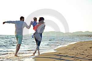 Portrait of happy family and baby enjoying sunset in the summer leisure