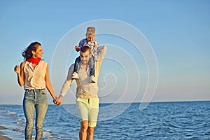 Portrait of happy family and baby enjoying sunset in the summer leisure