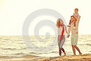 Portrait of happy family and baby enjoying sunset in the summer leisure