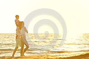 Portrait of happy family and baby enjoying sunset in the summer leisure