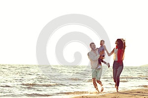 Portrait of happy family and baby enjoying sunset in the summer leisure