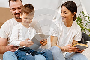 Portrait of happy family with cardboard boxes in new house at moving day