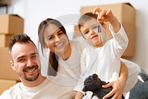 Portrait of happy family with cardboard boxes in new house at moving day