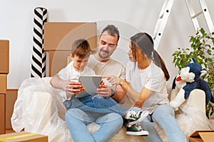 Portrait of happy family with cardboard boxes in new house at moving day