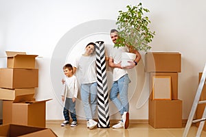 Portrait of happy family with cardboard boxes in new house at moving day