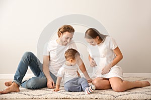 Portrait of happy family on carpet near white wall