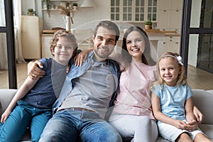 Portrait of happy family with children relaxing at home