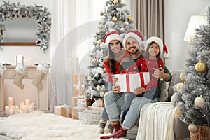 Portrait of happy family with Christmas gift, space for text