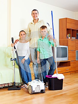 Portrait of happy family with cleaning equipment