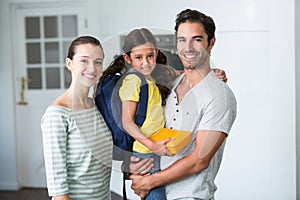 Portrait of happy family with daughter holding lunch box