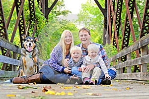 Portrait of Happy Family and Dog Outside in Fall