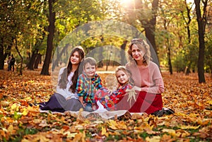 Portrait of happy family in forest park in autumn colorful landscape, motherhood and carefree childhood in nature outdoors