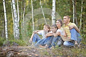 Portrait of happy family of four in autumn park