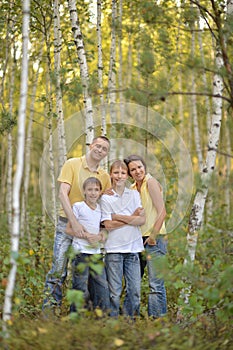 Portrait of happy family of four in autumn park